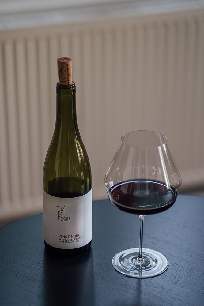 Eine Flasche Pinot Noir vom Weingut Paul Achs und ein Glas von Mark Thomas gefüllt mit dem Pinot.